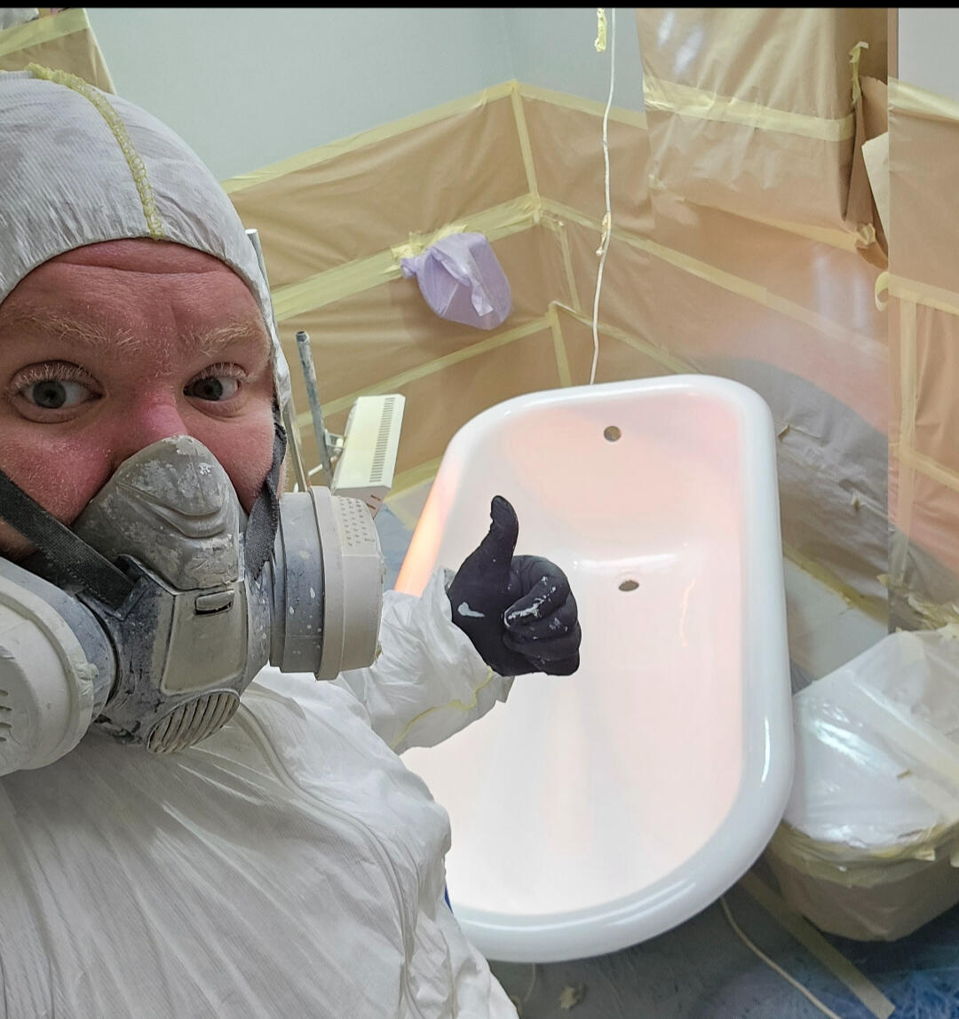 photo of glossy baths re-enamelling owner Seamus with a thumbs up, in ppe, in a room full of masking up and a completed bath in Weston-super-Mare